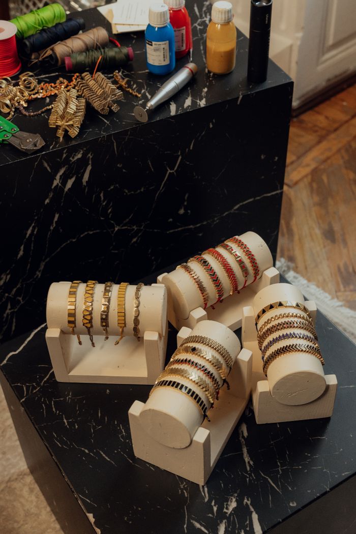 Collection of handmade bracelets displayed on a stylish marble table in a workshop setting.